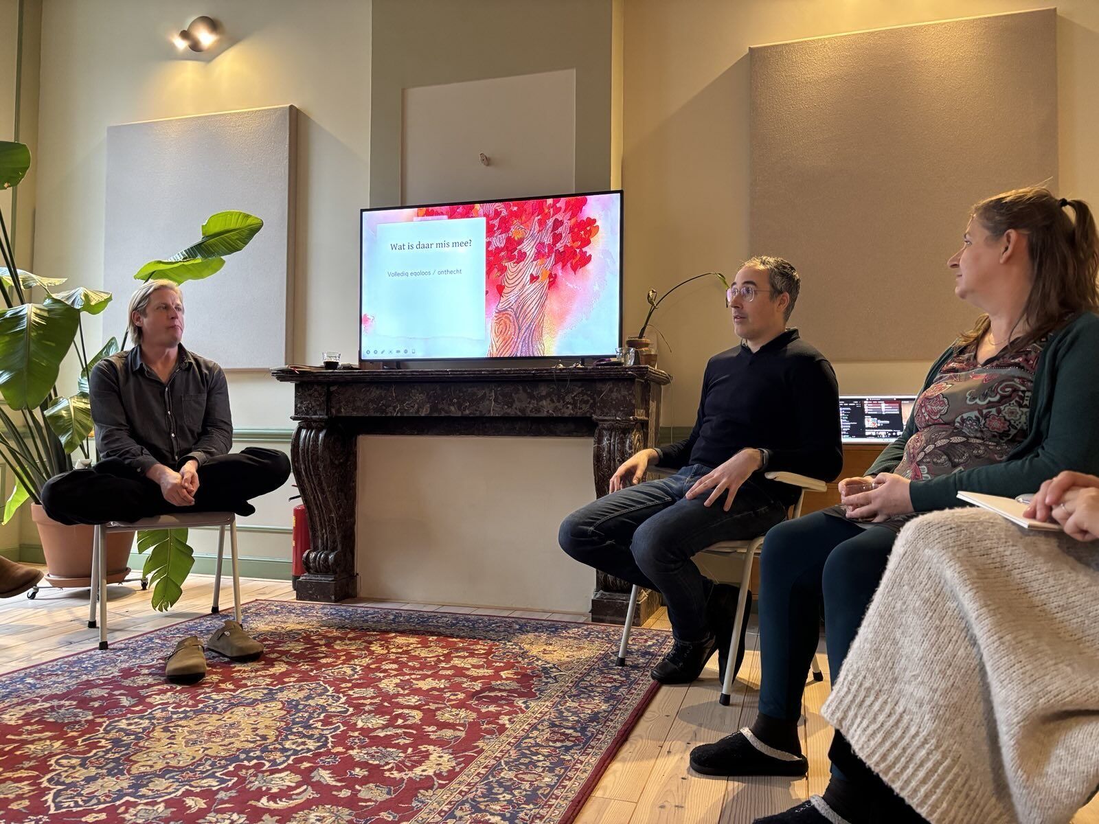 A small group seated in a circle during a session in a canal-house room