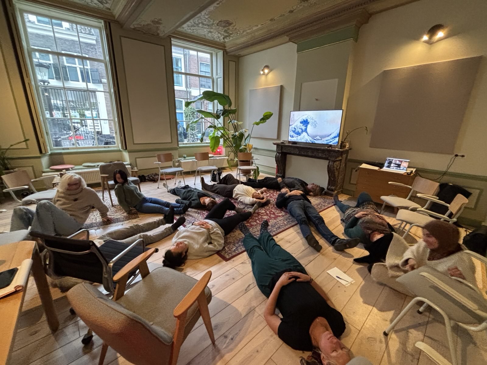 Participants lying on the floor during an experiential exercise in a training room